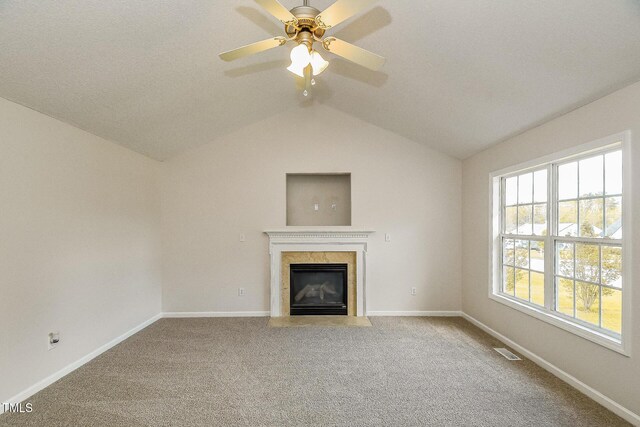 unfurnished living room with a high end fireplace, carpet, vaulted ceiling, and baseboards