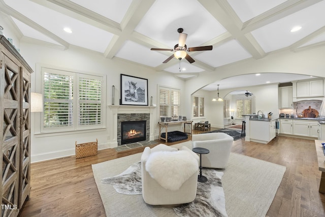 1211 New Grissom Way, Wake Forest, NC 27587 - living area featuring arched walkways, coffered ceiling, ceiling fan, a fireplace, and beamed ceiling
