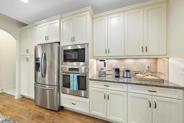 1211 New Grissom Way, Wake Forest, NC 27587 - kitchen featuring stainless steel appliances, cream cabinets, arched walkways, and backsplash
