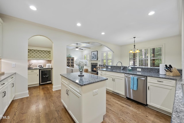 1211 New Grissom Way, Wake Forest, NC 27587 - kitchen with beverage cooler, dishwasher, a sink, a lit fireplace, and backsplash