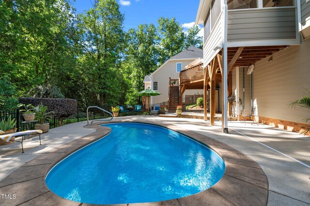 view of swimming pool with stairway, a patio, and a deck