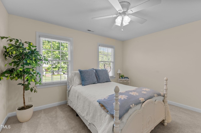 bedroom with light colored carpet, baseboards, and ceiling fan