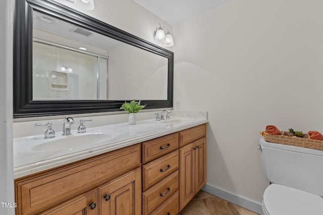 full bath with toilet, double vanity, tile patterned floors, and baseboards