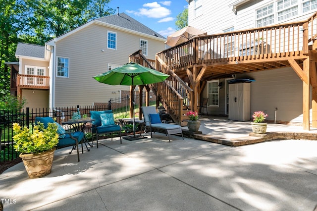 rear view of house featuring a patio, fence, and a deck