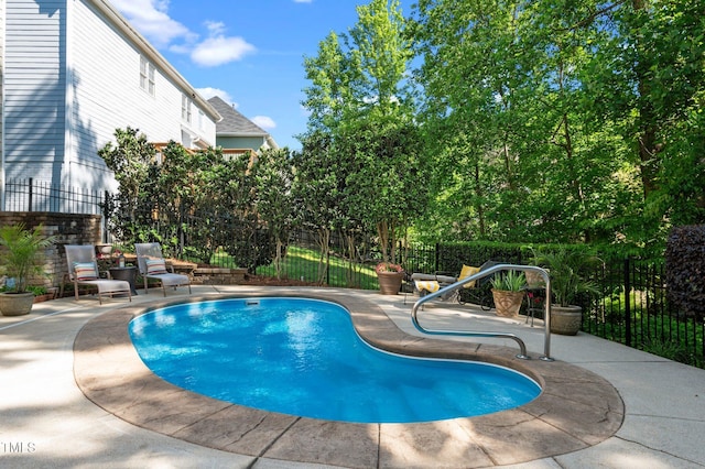 view of swimming pool featuring fence and a patio area