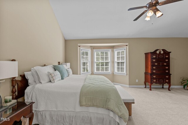 bedroom featuring light colored carpet, baseboards, ceiling fan, and vaulted ceiling