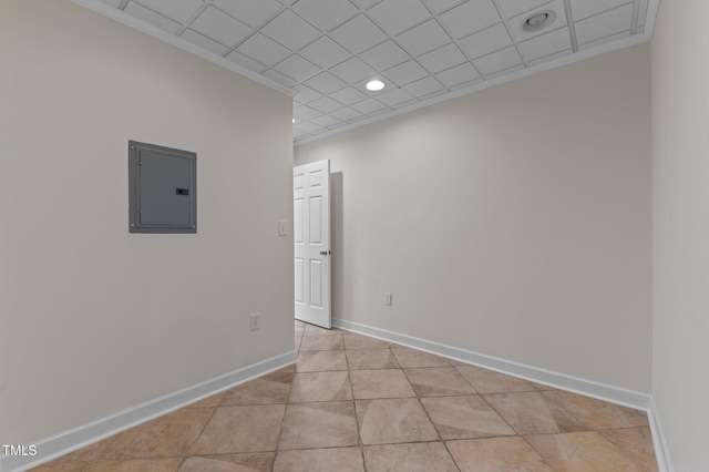 empty room featuring electric panel, ornamental molding, recessed lighting, light tile patterned floors, and baseboards