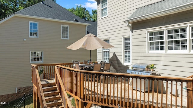 wooden deck featuring a grill and outdoor dining area