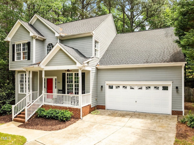 traditional-style house featuring a porch, an attached garage, a shingled roof, and concrete driveway