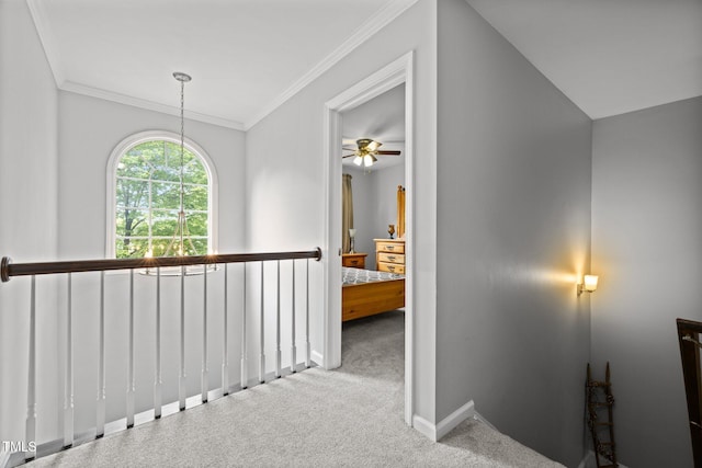 hallway featuring crown molding, an upstairs landing, baseboards, and carpet floors
