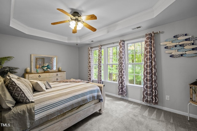 carpeted bedroom with a raised ceiling, ornamental molding, baseboards, and ceiling fan