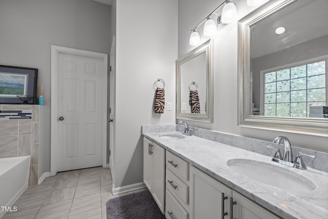 full bath with double vanity, tile patterned floors, a bath, and baseboards
