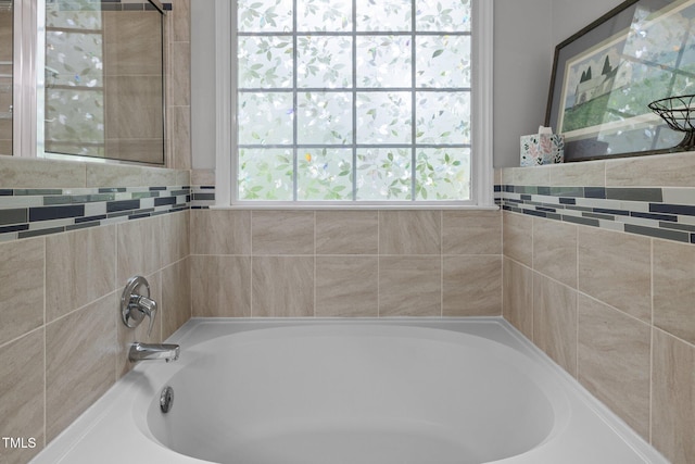full bathroom with a garden tub and healthy amount of natural light