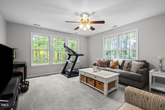carpeted living room with ceiling fan and baseboards