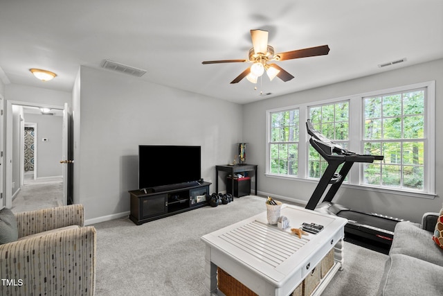 carpeted living room featuring a ceiling fan and baseboards