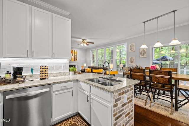 kitchen featuring dishwasher, a sink, a peninsula, ceiling fan, and white cabinets