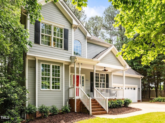 traditional home with a garage, concrete driveway, covered porch, and fence