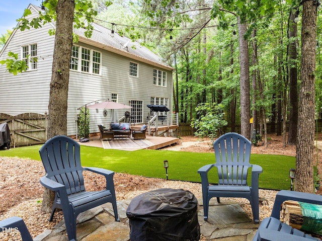 back of property with an outdoor living space, a patio area, a gate, and a deck