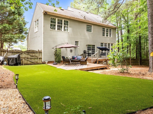rear view of property featuring a deck, a patio area, a gate, and an outdoor hangout area