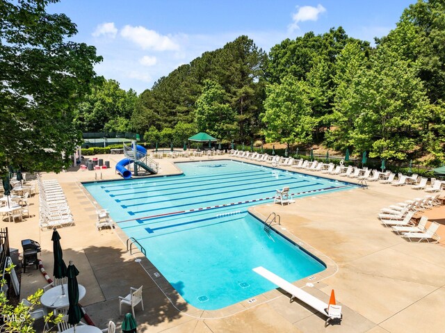 1204 Benoit Pl, Apex, NC 27502 - community pool with a water slide, fence, a diving board, and a patio area