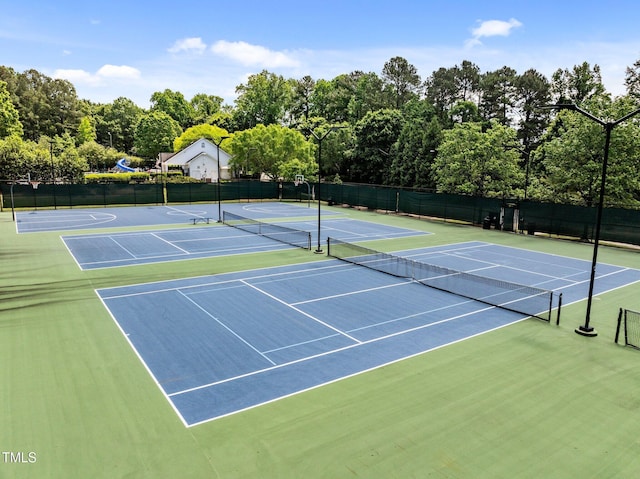 view of tennis court with community basketball court and fence