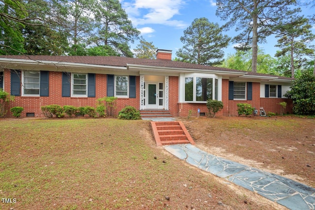 ranch-style home with crawl space, brick siding, a chimney, and a front yard