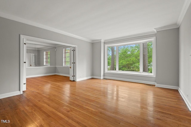 spare room featuring wood finished floors, baseboards, and ornamental molding