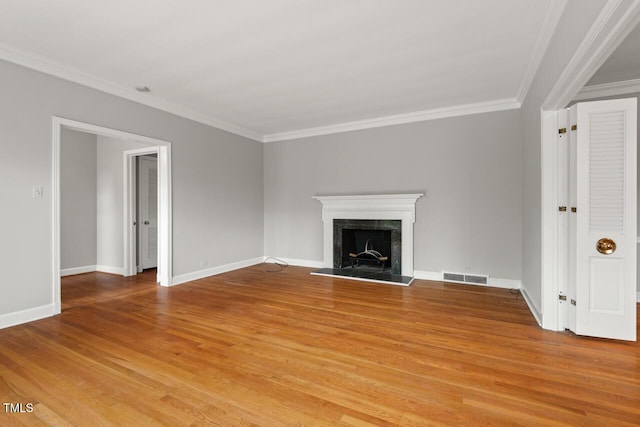 unfurnished living room with light wood-type flooring, ornamental molding, a premium fireplace, and baseboards