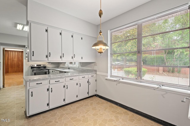 kitchen featuring electric stove, white cabinetry, light countertops, hanging light fixtures, and baseboards