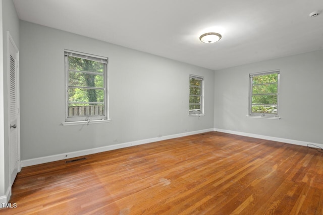 unfurnished room with light wood-style flooring, baseboards, and a smoke detector