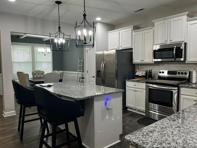 116 Georgia Dr, Raeford, NC 28376 - kitchen featuring stainless steel appliances, a center island, a chandelier, white cabinetry, and recessed lighting