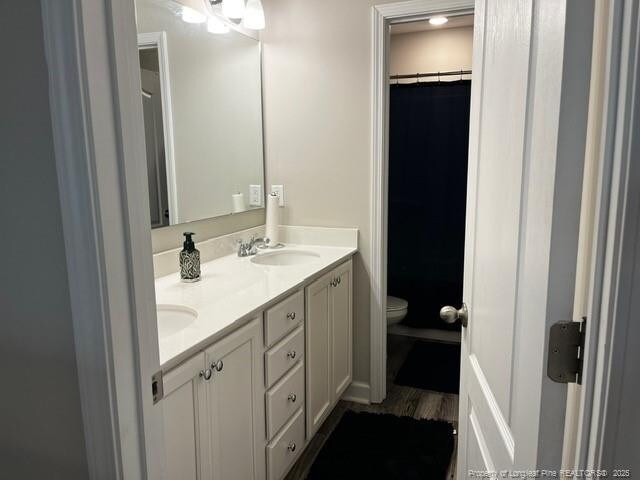 116 Georgia Dr, Raeford, NC 28376 - full bath featuring toilet, double vanity, wood finished floors, and a shower with shower curtain