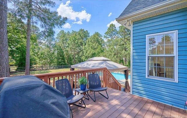 deck with a fenced backyard and outdoor dining space