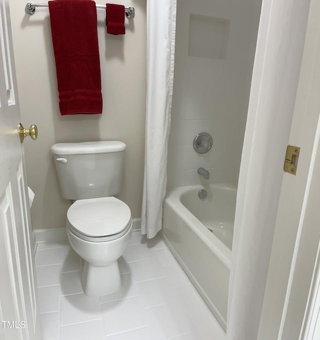 full bathroom with baseboards, tile patterned flooring, toilet, and shower / bath combo