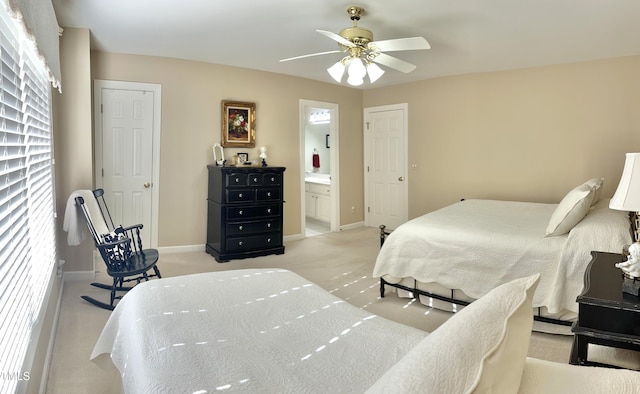 bedroom featuring light colored carpet, baseboards, connected bathroom, and ceiling fan
