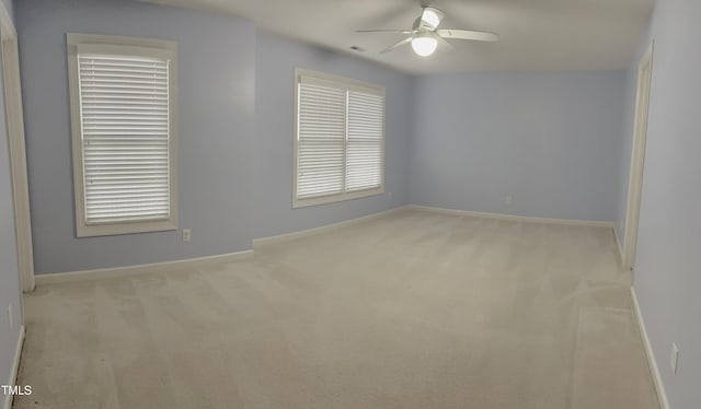 spare room with carpet floors, ceiling fan, and baseboards