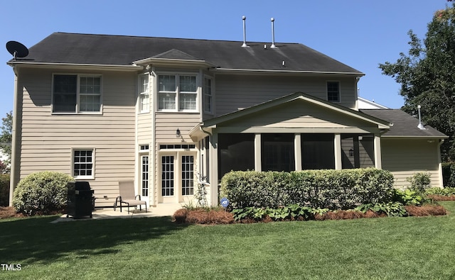 back of property with a lawn, a sunroom, and a patio