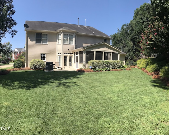 back of house with a yard, a sunroom, and a patio area