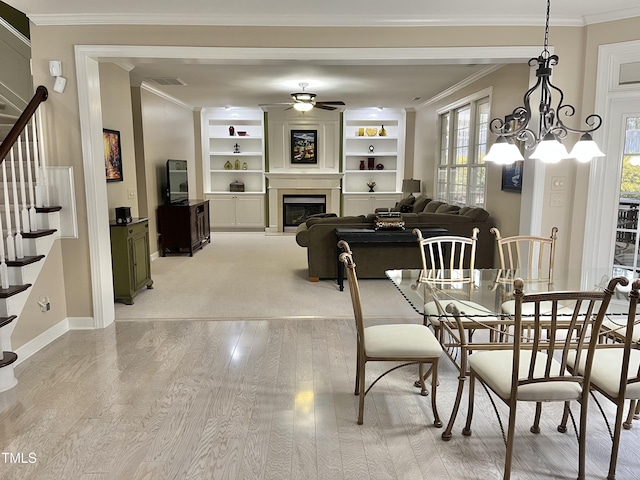 dining room with ornamental molding, light wood-type flooring, stairway, ceiling fan, and baseboards