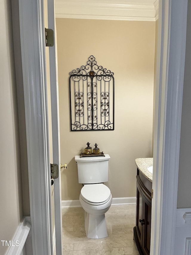 half bath with ornamental molding, baseboards, vanity, and toilet