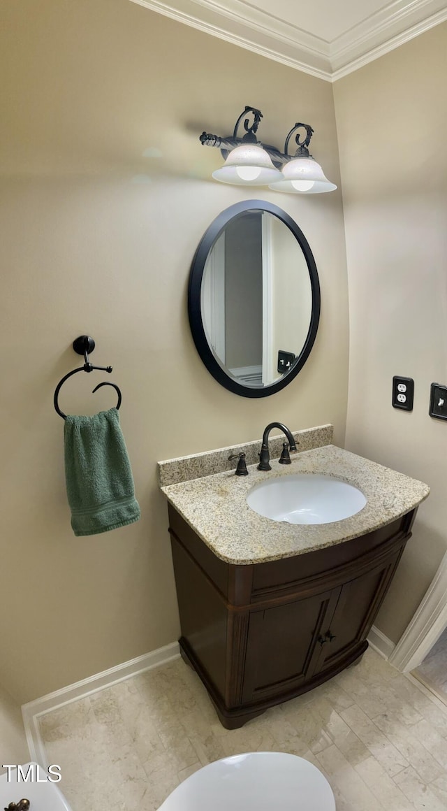 bathroom with ornamental molding, vanity, and baseboards