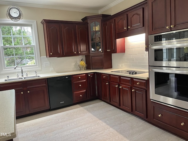 kitchen featuring black appliances, a sink, light countertops, ornamental molding, and tasteful backsplash