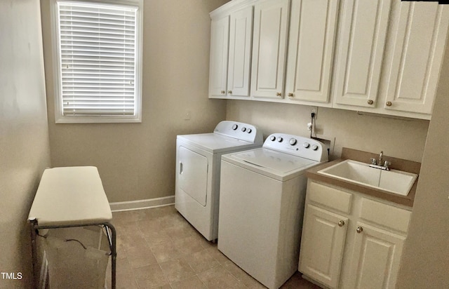 washroom with separate washer and dryer, cabinet space, and baseboards