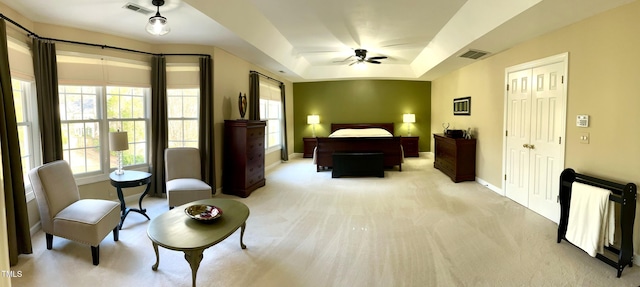 bedroom with light colored carpet, baseboards, a raised ceiling, a closet, and ceiling fan