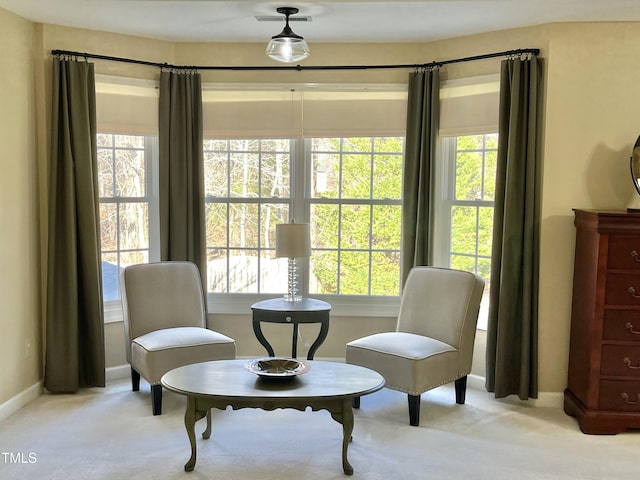 sitting room featuring light carpet and baseboards