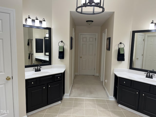 bathroom with tile patterned flooring, two vanities, and baseboards