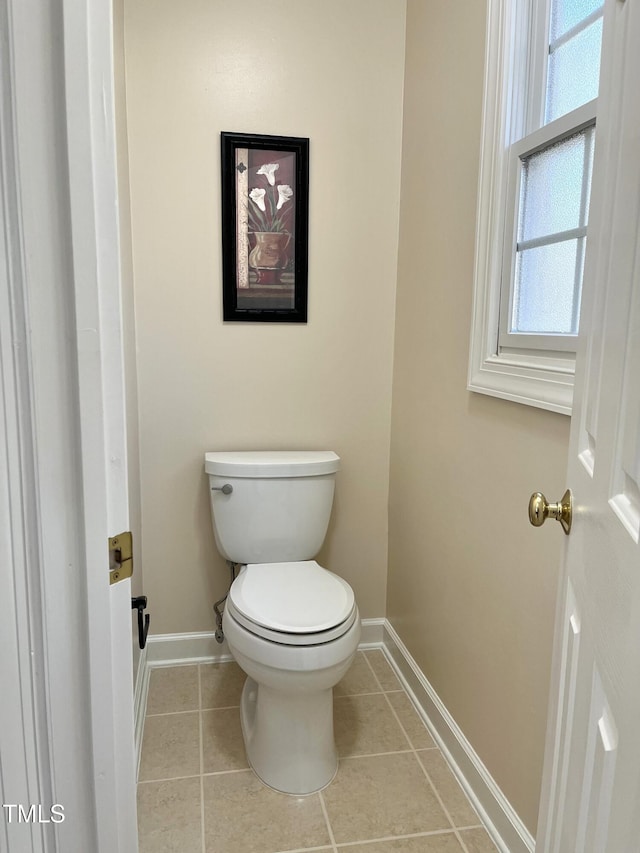 bathroom with baseboards, toilet, and tile patterned floors