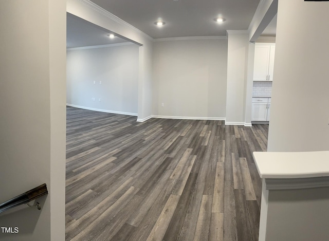 unfurnished living room with dark wood-type flooring, recessed lighting, baseboards, and crown molding