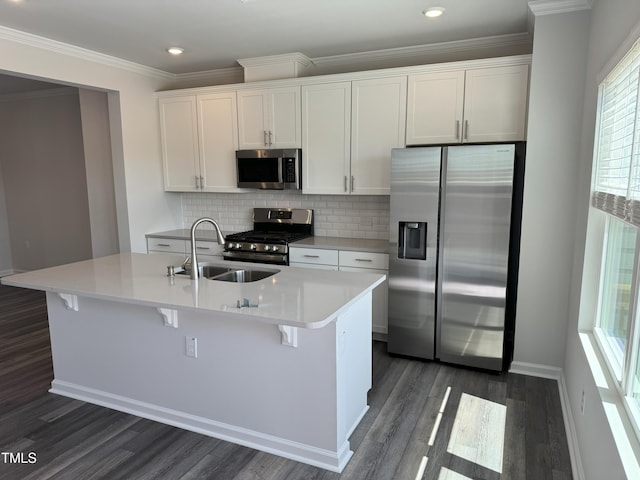 kitchen featuring appliances with stainless steel finishes, a sink, dark wood-type flooring, a center island with sink, and white cabinets