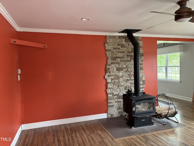 704 S Mineral Springs Rd, Durham, NC 27703 - detailed view of a wood stove, baseboards, ornamental molding, wood finished floors, and ceiling fan